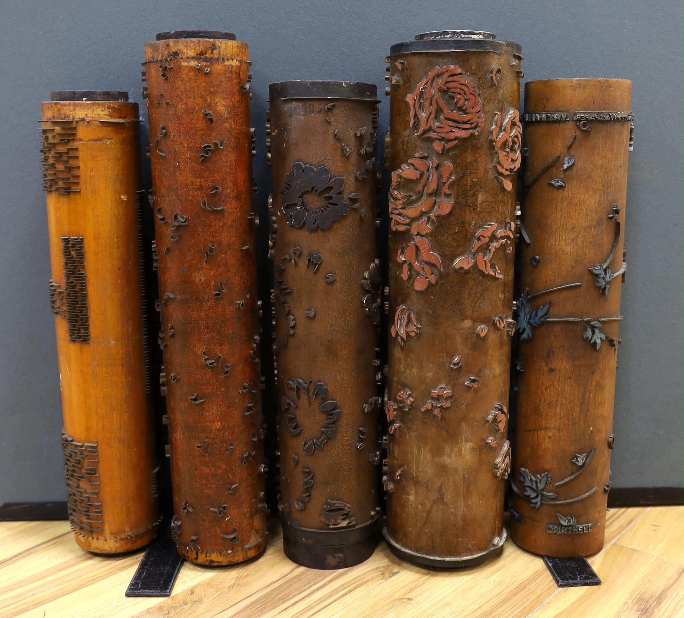 Five USA wooden print rollers for wallpaper, late 19th century, including a UWPC (United Wall Paper Craftsmen of North America) example, another stamped with serial numbers, longest 60.5cm
